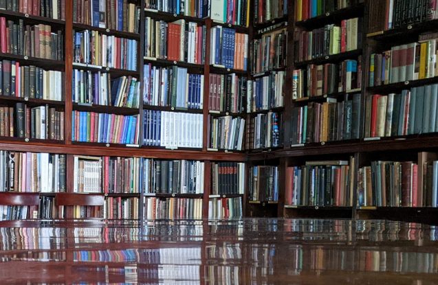 Library shelves reflected on polished dining table